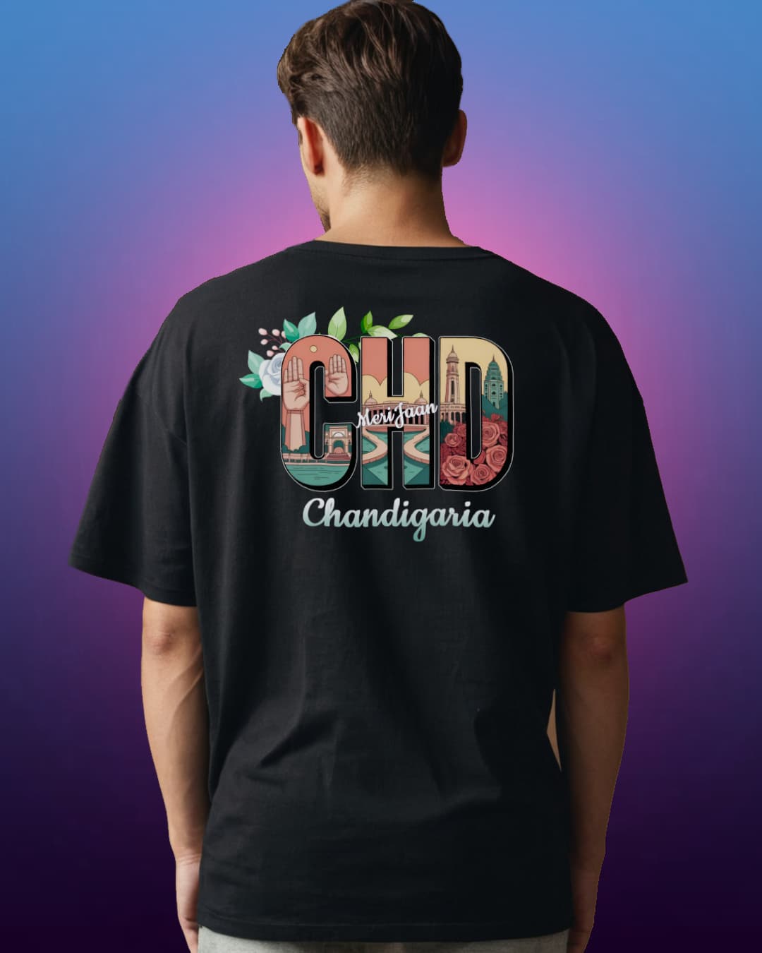 Back view of a man wearing a black CHD Chandigarh Oversized T-Shirt with city vibe design in bold letters, featuring iconic Chandigarh landmarks. Made with 210 GSM French Terry fabric.